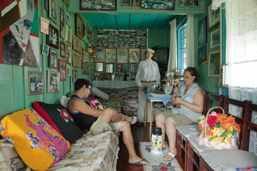 Family gathered in a memory-filled living room covered with framed photographs, O Destino de Um Coração