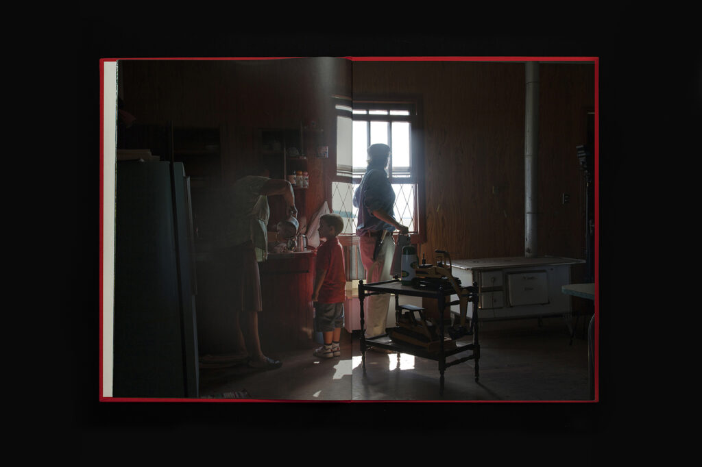Open photobook spread from O Destino de Um Coração showing interior domestic scene with window light.