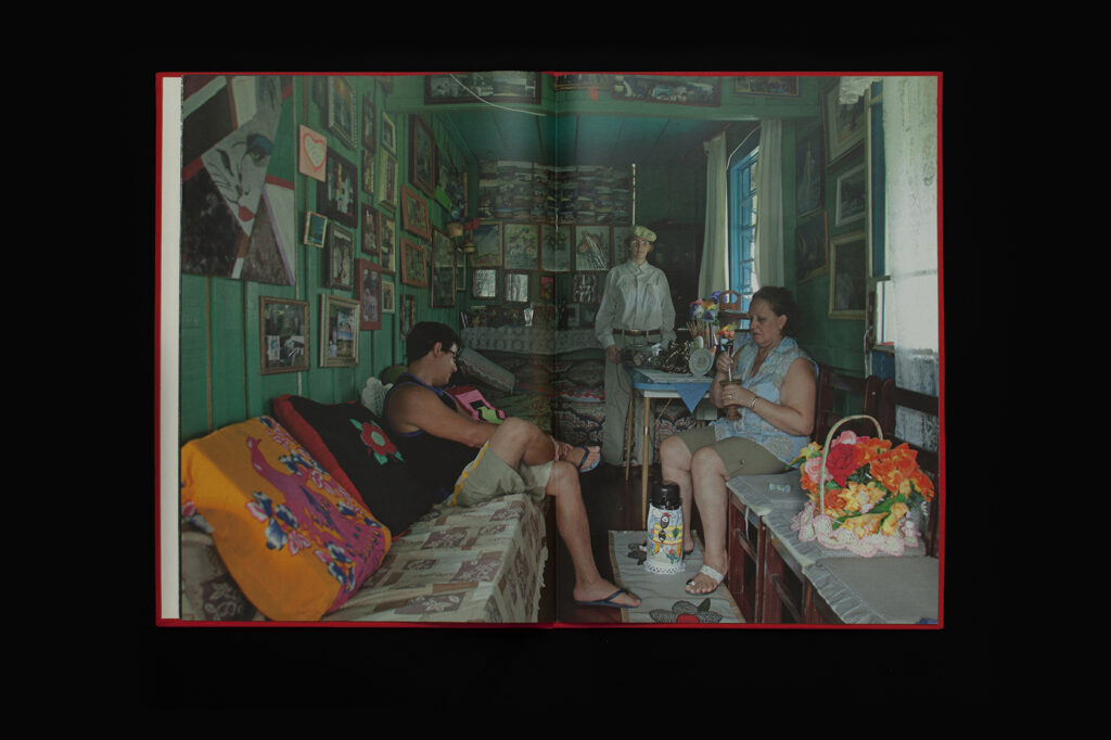 Open photobook spread from O Destino de Um Coração showing interior family scene across two pages.